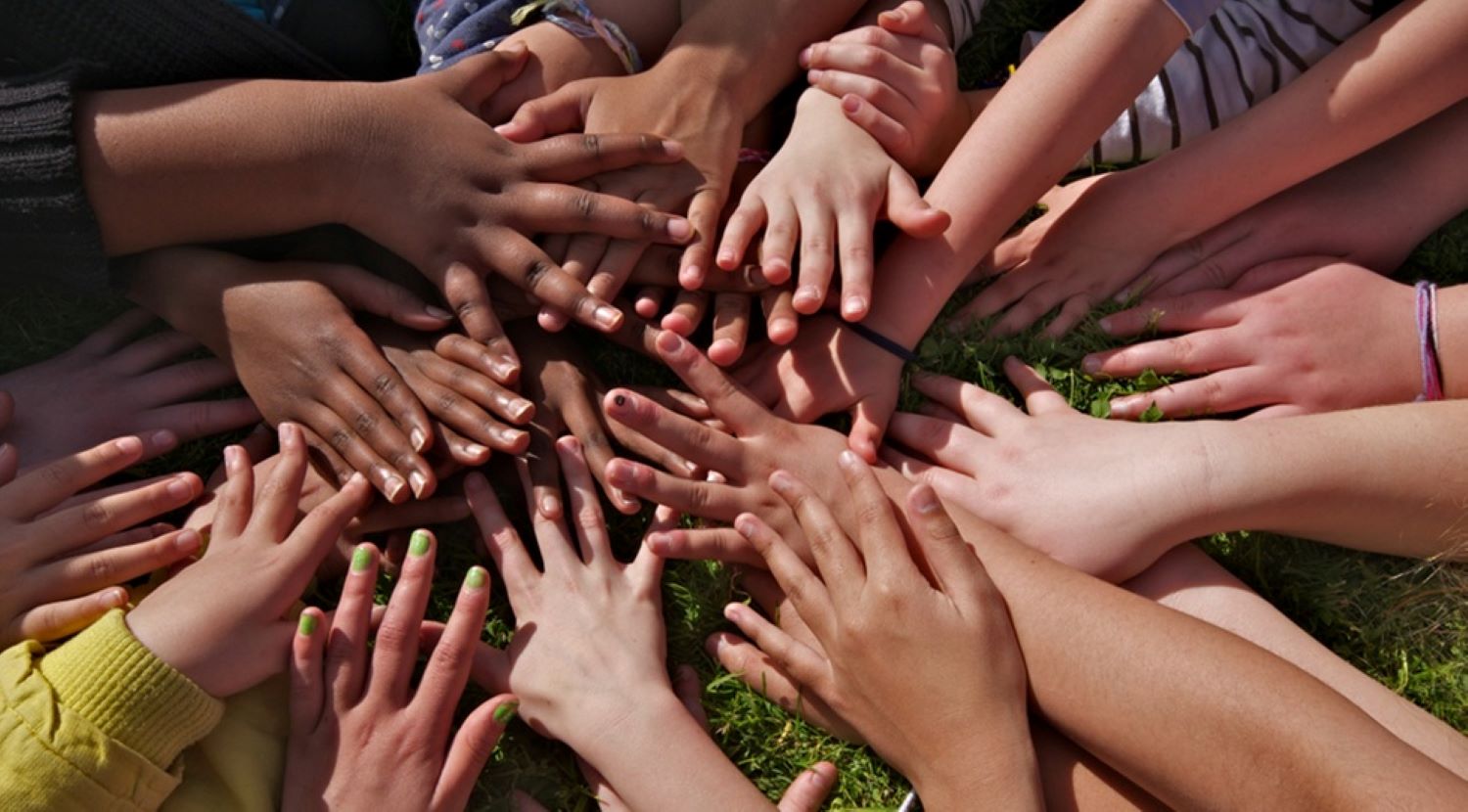 Fiften people's hands lying atop one another