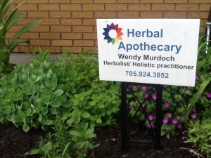Herbal Apothecary sign in a garden of  herbs and flowers