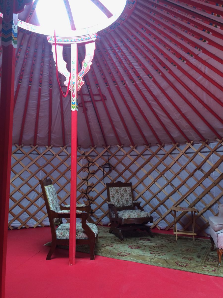 Inside Krow's yurt Inside of a yurt with red and white interior and two chairs